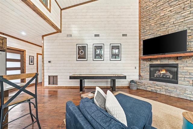 168 Eagle Mountain Trl, Broken Bow, OK 74728 - living area featuring wood finished floors, wood walls, a stone fireplace, a towering ceiling, and recessed lighting