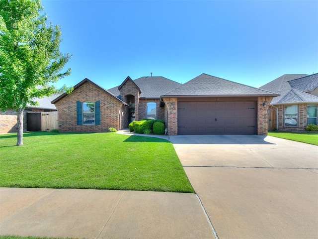 17016 Barcelona Dr, Oklahoma City, OK 73170 - french country style house featuring brick siding, an attached garage, driveway, and a shingled roof
