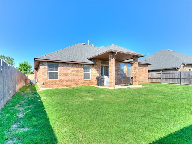 17016 Barcelona Dr, Oklahoma City, OK 73170 - rear view of property featuring brick siding, a patio area, and roof with shingles