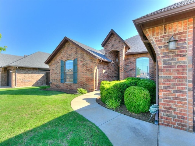 17016 Barcelona Dr, Oklahoma City, OK 73170 - view of front of house with brick siding, a front yard, and roof with shingles