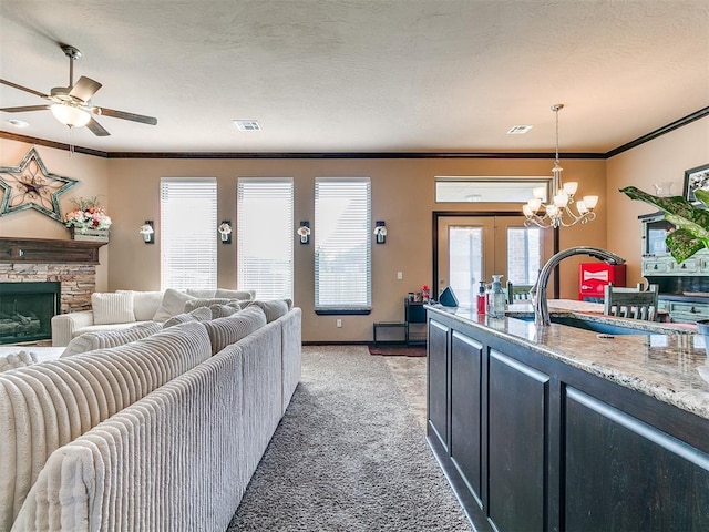 17016 Barcelona Dr, Oklahoma City, OK 73170 - living room featuring light carpet, ornamental molding, a fireplace, a chandelier, and a ceiling fan