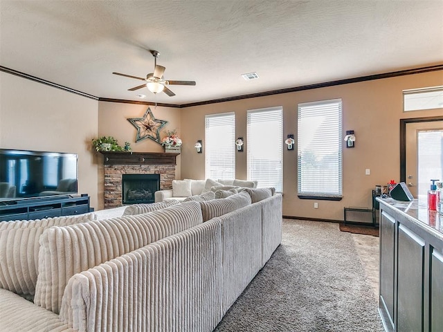 17016 Barcelona Dr, Oklahoma City, OK 73170 - living area with a ceiling fan, ornamental molding, light carpet, a stone fireplace, and baseboards