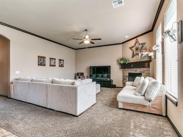 17016 Barcelona Dr, Oklahoma City, OK 73170 - carpeted living area featuring arched walkways, ornamental molding, ceiling fan, a fireplace, and baseboards