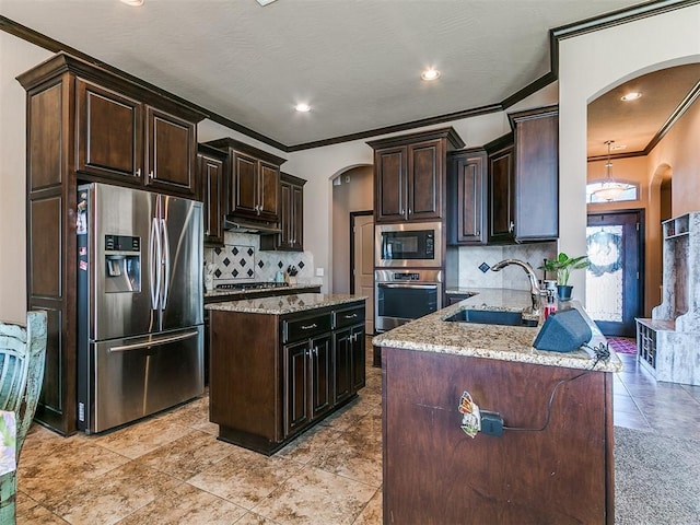 17016 Barcelona Dr, Oklahoma City, OK 73170 - kitchen with arched walkways, appliances with stainless steel finishes, a sink, crown molding, and light stone countertops