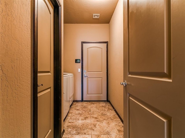 17016 Barcelona Dr, Oklahoma City, OK 73170 - hall with independent washer and dryer, a textured wall, and baseboards