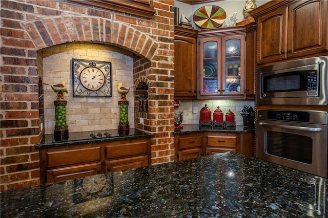 16000 SW 25th St, Oklahoma City, OK 73036 - kitchen featuring stainless steel appliances, dark stone counters, glass insert cabinets, and tasteful backsplash