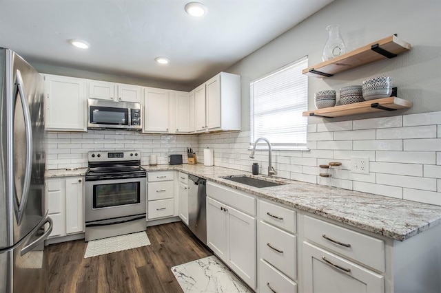 9800 Hummingbird Ln, Oklahoma City, OK 73162 - kitchen featuring stainless steel appliances, a sink, white cabinetry, tasteful backsplash, and dark wood-type flooring