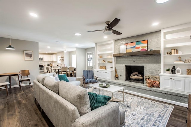 9800 Hummingbird Ln, Oklahoma City, OK 73162 - living area featuring baseboards, ceiling fan, dark wood-style flooring, recessed lighting, and a brick fireplace