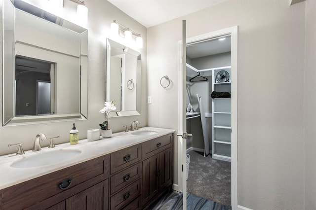 9800 Hummingbird Ln, Oklahoma City, OK 73162 - full bath with double vanity, a walk in closet, and baseboards