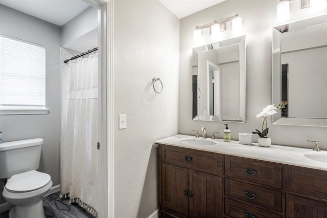 9800 Hummingbird Ln, Oklahoma City, OK 73162 - bathroom featuring double vanity, toilet, and baseboards