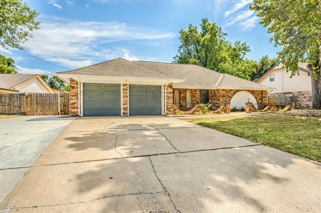 9800 Hummingbird Ln, Oklahoma City, OK 73162 - ranch-style home featuring an attached garage, driveway, and roof with shingles