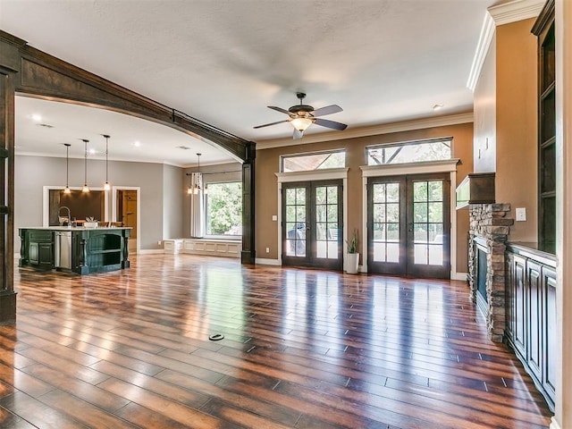 4216 SE 86th Pl, Oklahoma City, OK 73135 - unfurnished living room featuring a ceiling fan, crown molding, hardwood / wood-style flooring, a sink, and a stone fireplace