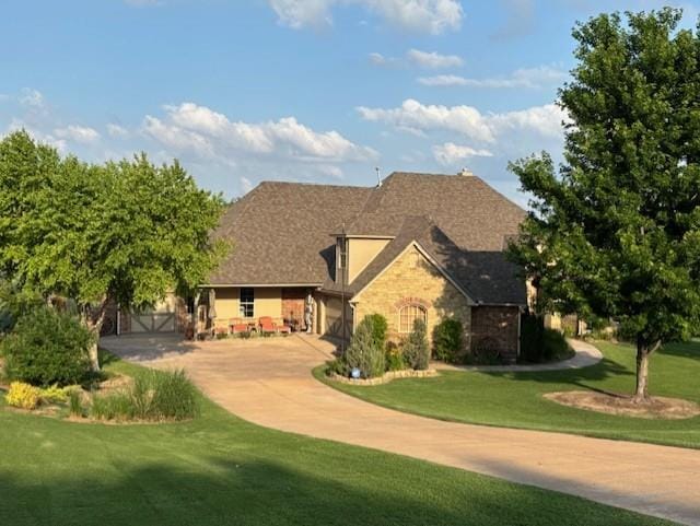 6706 Valley Ridge Dr, Edmond, OK 73034 - view of front of home with a front lawn, stone siding, driveway, and an attached garage