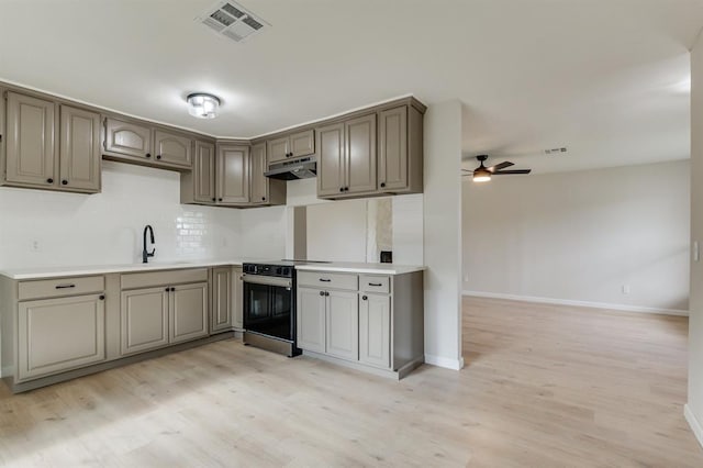 812 NW 113th St, Oklahoma City, OK 73114 - kitchen with range with electric stovetop, under cabinet range hood, a ceiling fan, light wood finished floors, and baseboards