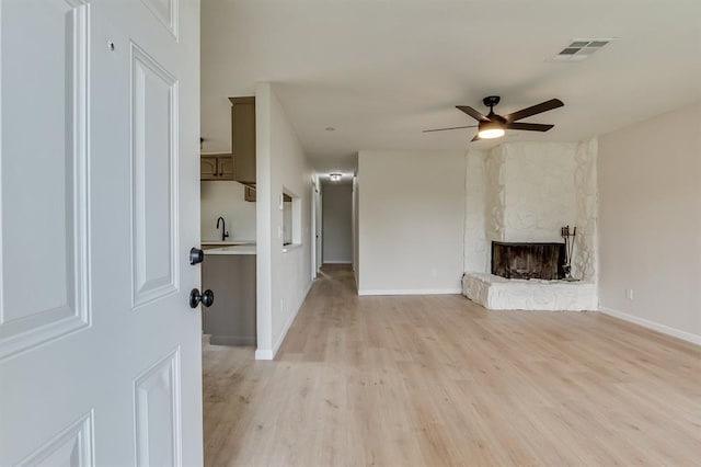 812 NW 113th St, Oklahoma City, OK 73114 - unfurnished living room with a ceiling fan, light wood-style flooring, a fireplace, and baseboards