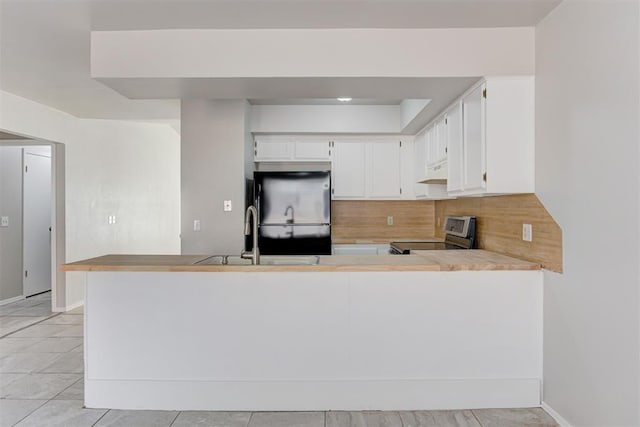 201 Kathleen Dr, Midwest City, OK 73110 - kitchen featuring freestanding refrigerator, stainless steel electric stove, a sink, decorative backsplash, and under cabinet range hood