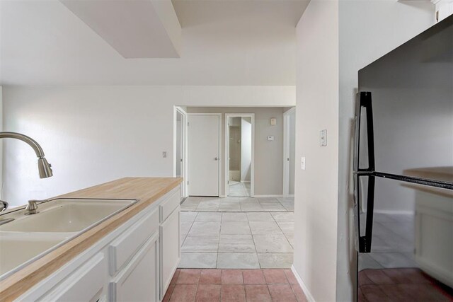 201 Kathleen Dr, Midwest City, OK 73110 - kitchen with freestanding refrigerator, a sink, white cabinetry, and light countertops