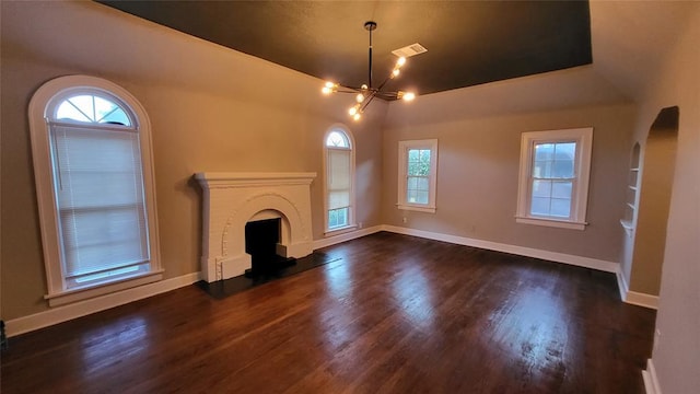 929 NE 21st St, Oklahoma City, OK 73105 - unfurnished living room featuring a chandelier, dark wood-style flooring, and plenty of natural light