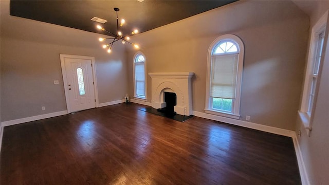 929 NE 21st St, Oklahoma City, OK 73105 - unfurnished living room featuring a chandelier, dark wood-style floors, and baseboards