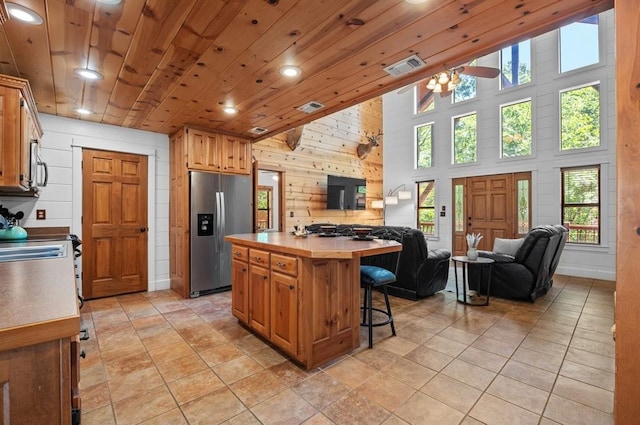 83 Bobber Rd, Broken Bow, OK 74728 - kitchen featuring appliances with stainless steel finishes, open floor plan, wooden walls, recessed lighting, and a kitchen bar