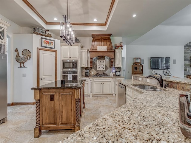 3122 Thornbrooke Blvd, Edmond, OK 73013 - kitchen featuring a sink, built in appliances, a tray ceiling, backsplash, and light stone countertops