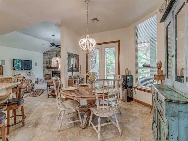 3122 Thornbrooke Blvd, Edmond, OK 73013 - dining space featuring a ceiling fan, lofted ceiling, a chandelier, a stone fireplace, and baseboards