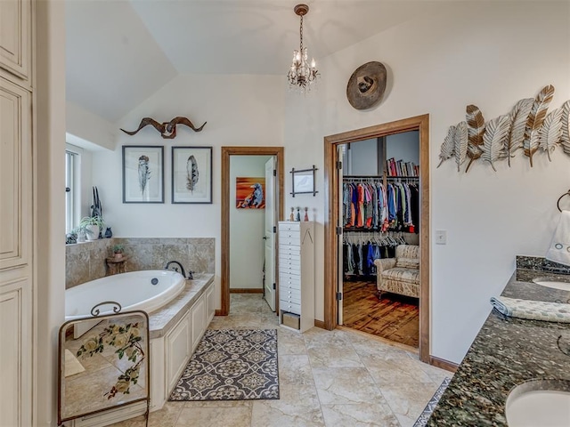 3122 Thornbrooke Blvd, Edmond, OK 73013 - bathroom with double vanity, a garden tub, vaulted ceiling, a spacious closet, and a chandelier
