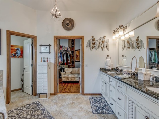 3122 Thornbrooke Blvd, Edmond, OK 73013 - full bath with double vanity, a walk in closet, a chandelier, and baseboards