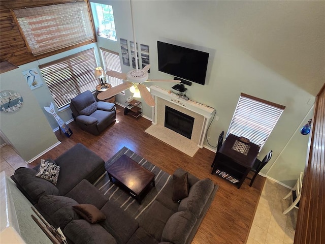 110534 S 4183rd Rd, Checotah, OK 74426 - living area with a ceiling fan, wood finished floors, a towering ceiling, baseboards, and a premium fireplace