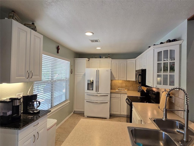 110534 S 4183rd Rd, Checotah, OK 74426 - kitchen featuring black appliances, a sink, decorative backsplash, white cabinets, and glass insert cabinets