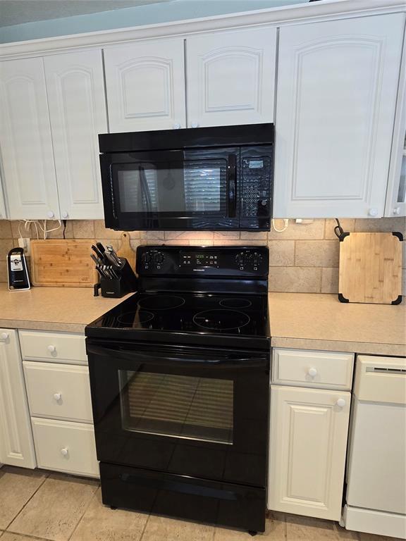 110534 S 4183rd Rd, Checotah, OK 74426 - kitchen with black appliances, light countertops, tasteful backsplash, white cabinetry, and light tile patterned floors