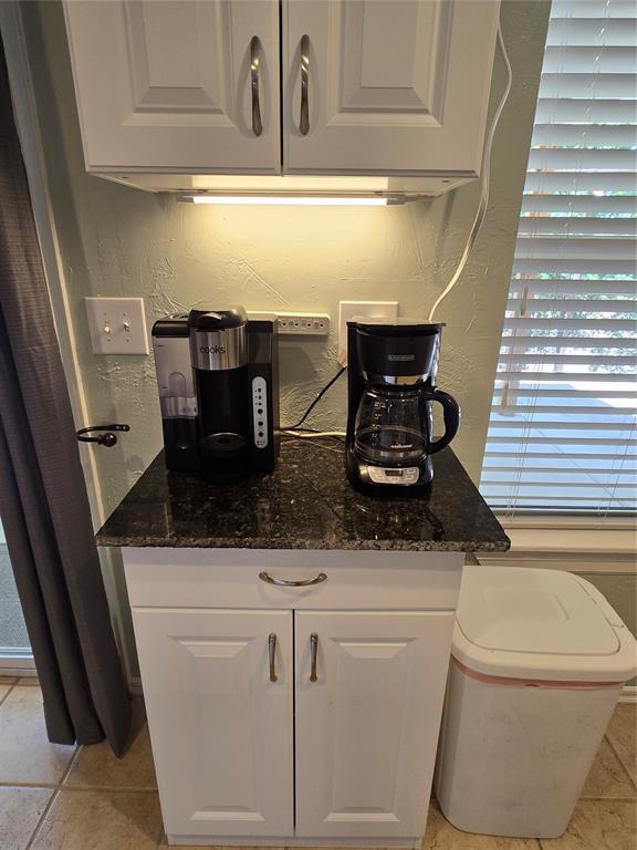 110534 S 4183rd Rd, Checotah, OK 74426 - kitchen with white cabinets, dark stone counters, and a textured wall