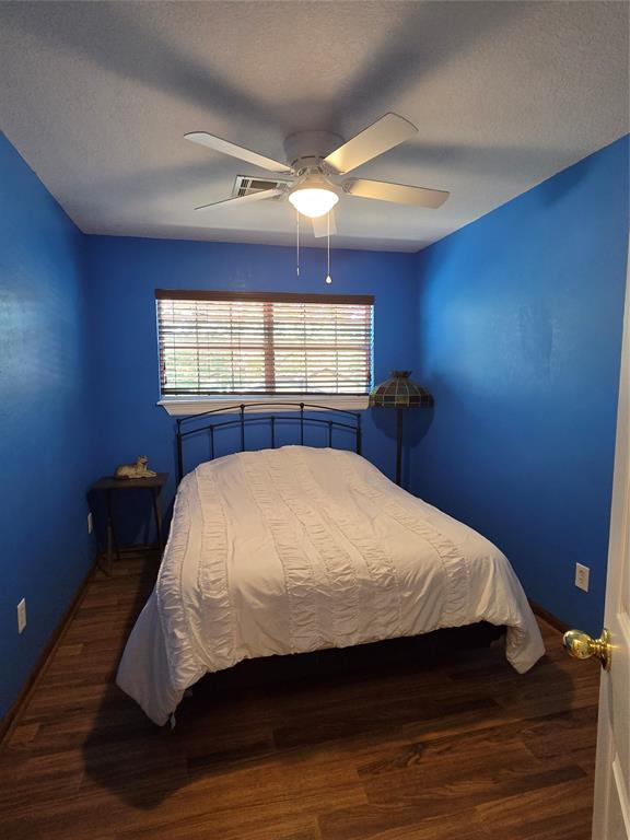 110534 S 4183rd Rd, Checotah, OK 74426 - bedroom featuring ceiling fan, wood finished floors, baseboards, and a textured ceiling