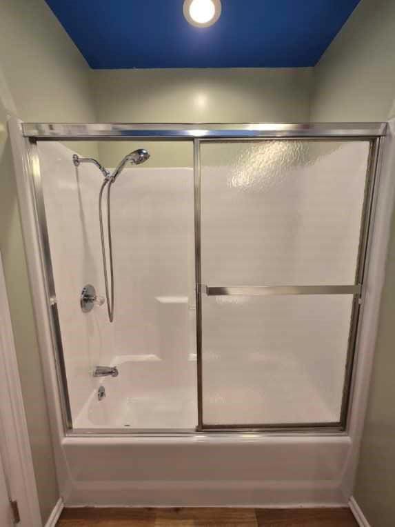 110534 S 4183rd Rd, Checotah, OK 74426 - bathroom with bath / shower combo with glass door, wood finished floors, and baseboards