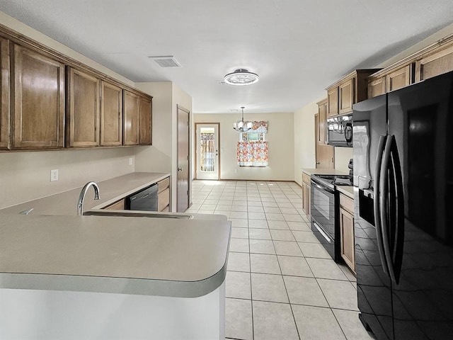 3105 SW 104th Ter, Oklahoma City, OK 73159 - kitchen with black appliances, light tile patterned floors, a chandelier, light countertops, and decorative light fixtures