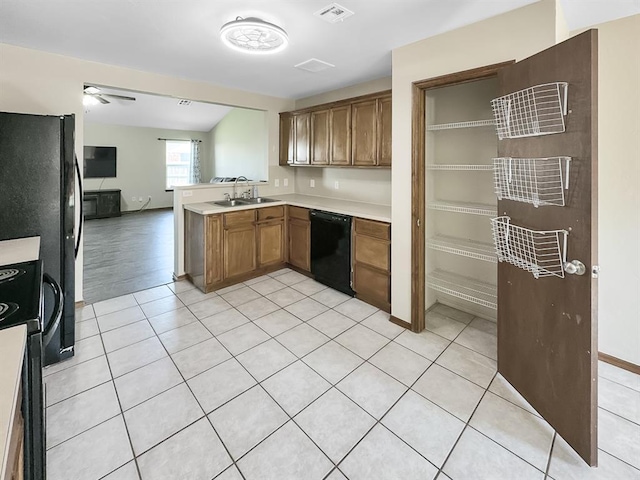 3105 SW 104th Ter, Oklahoma City, OK 73159 - kitchen with black appliances, a sink, light countertops, and light tile patterned floors