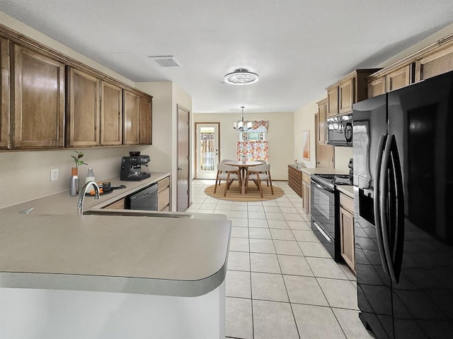 3105 SW 104th Ter, Oklahoma City, OK 73159 - kitchen featuring black appliances, light tile patterned flooring, a chandelier, light countertops, and a peninsula