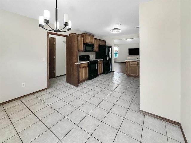 3105 SW 104th Ter, Oklahoma City, OK 73159 - kitchen featuring black appliances, a chandelier, light countertops, light tile patterned floors, and hanging light fixtures