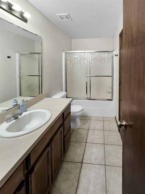 3105 SW 104th Ter, Oklahoma City, OK 73159 - full bath with vanity, toilet, shower / bath combination with glass door, and tile patterned floors