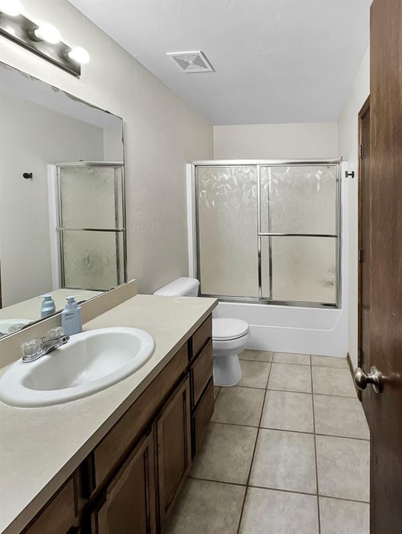 3105 SW 104th Ter, Oklahoma City, OK 73159 - bathroom with vanity, toilet, combined bath / shower with glass door, and tile patterned floors