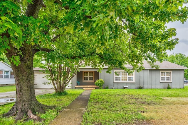408 S 6th St, Davis, OK 73030 - view of front of property with an attached garage, a front yard, board and batten siding, and covered porch