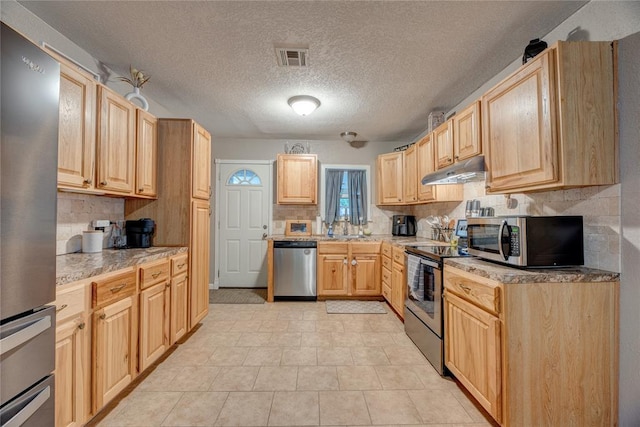 408 S 6th St, Davis, OK 73030 - kitchen featuring appliances with stainless steel finishes, under cabinet range hood, light brown cabinets, backsplash, and a textured ceiling