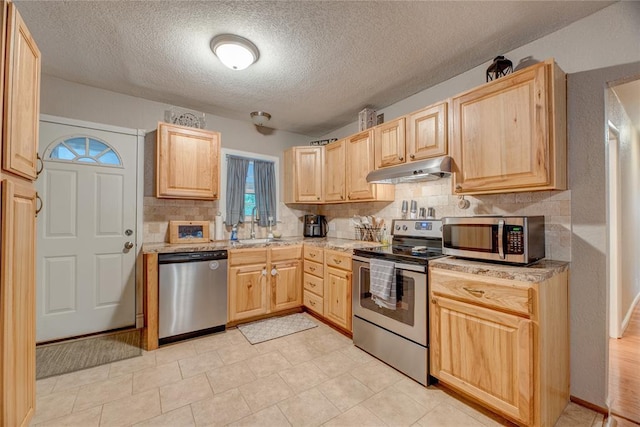 408 S 6th St, Davis, OK 73030 - kitchen with appliances with stainless steel finishes, under cabinet range hood, light brown cabinets, backsplash, and a textured ceiling