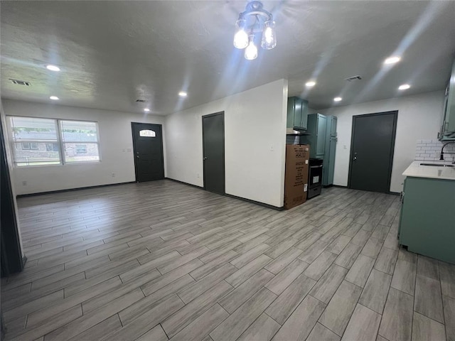 6505 NW 34th St, Bethany, OK 73008 - unfurnished living room featuring light wood-style floors, a sink, recessed lighting, and baseboards