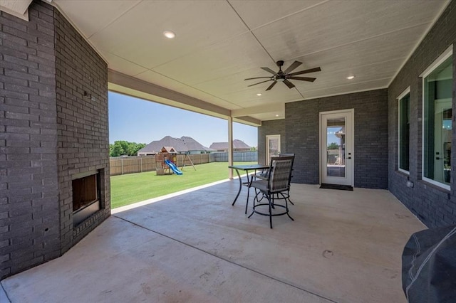 1008 Collis Way, Newcastle, OK 73065 - view of patio featuring a playground, an outdoor brick fireplace, and ceiling fan