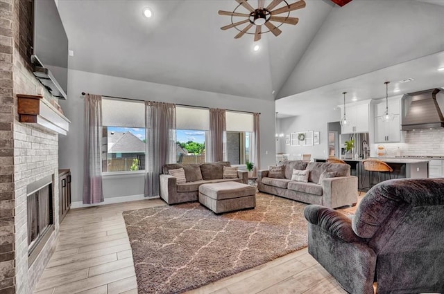 1008 Collis Way, Newcastle, OK 73065 - living room featuring ceiling fan, light wood-type flooring, high vaulted ceiling, a brick fireplace, and recessed lighting