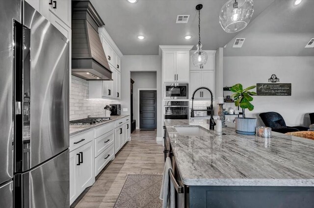 1008 Collis Way, Newcastle, OK 73065 - kitchen featuring stainless steel appliances, custom range hood, a sink, tasteful backsplash, and a large island with sink