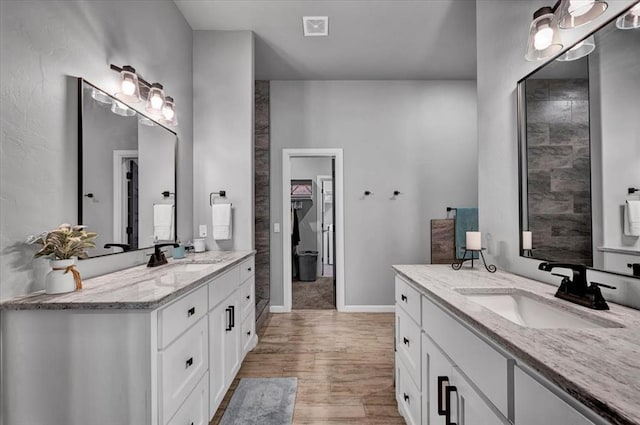 1008 Collis Way, Newcastle, OK 73065 - full bathroom featuring two vanities, wood finished floors, and baseboards