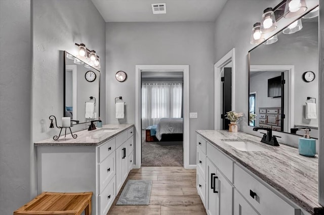 1008 Collis Way, Newcastle, OK 73065 - ensuite bathroom featuring two vanities and wood finished floors