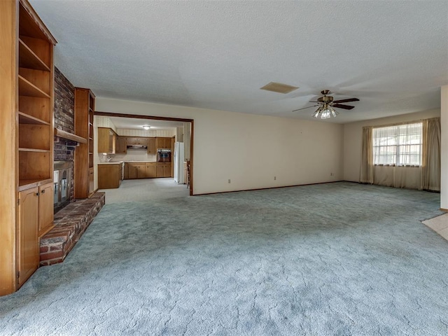 4004 N Shannon Ave, Bethany, OK 73008 - unfurnished living room with a fireplace, a ceiling fan, light carpet, and a textured ceiling